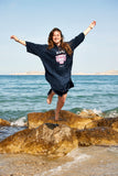 femme portant poncho bleu marine avec logo rose et blanc